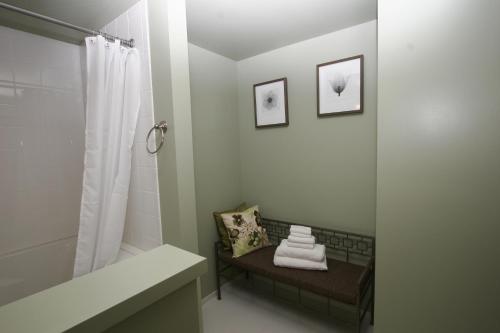 a bathroom with a shower and a bench with towels at Wildwood Farm Bed & Breakfast in Oak Harbor