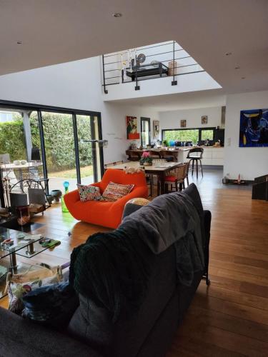 un salon avec un canapé orange et une cuisine dans l'établissement Annie-laure, à La Celle-sous-Gouzon