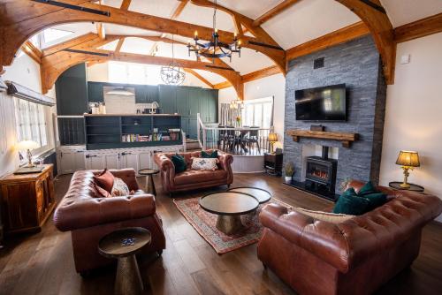 a living room with leather furniture and a fireplace at Greta Howe in Keswick