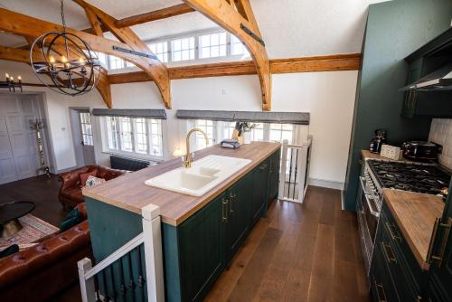 a kitchen with green cabinets and a sink at Greta Howe in Keswick