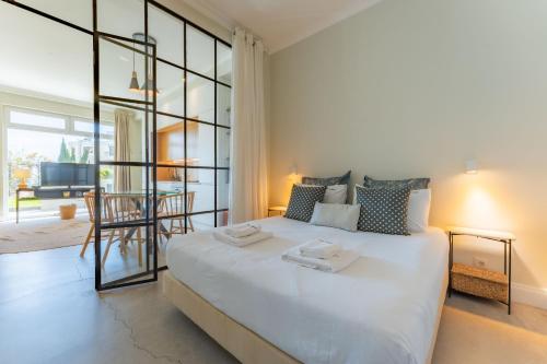 a bedroom with a large white bed and a living room at FLH Funchal Terrace Studio in Funchal