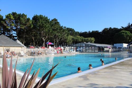 une grande piscine avec des gens dans l'eau dans l'établissement La petite folie, à Quiberon