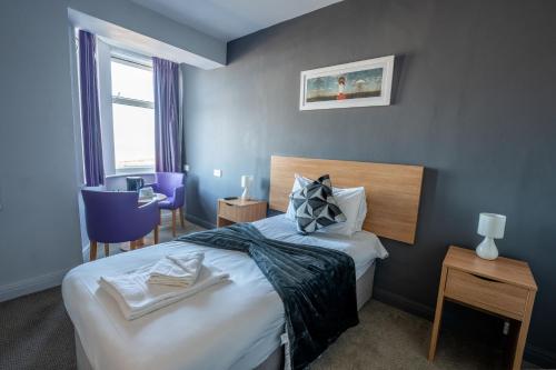 a hotel room with a bed and a window at The Strathmore Hotel in Morecambe