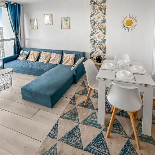 un salon avec un canapé bleu et une table dans l'établissement Lumineux avec balcon & confort familial, au Havre