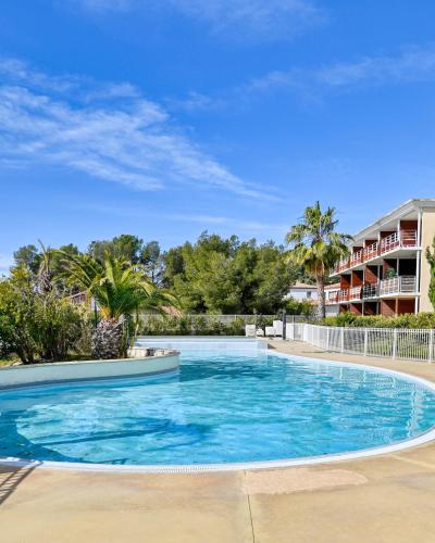 - une piscine d'eau bleue dans un complexe dans l'établissement Appartement 4 à 6 personnes La Ciotat, à La Ciotat