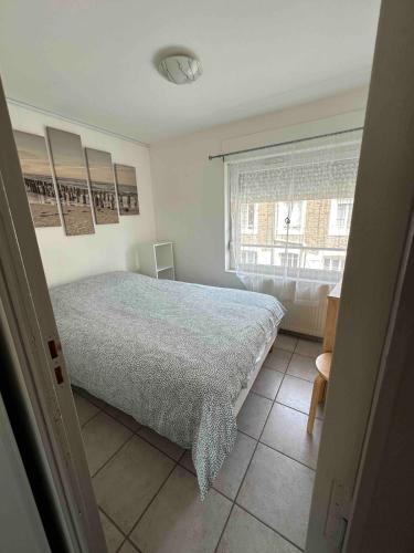 une chambre avec un grand lit et une fenêtre dans l'établissement Studio lumineux avec terrasse à 200 m de la plage, à Dinard