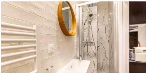 une salle de bain avec un lavabo et un miroir dans l'établissement Le Shade of Grey - Studio Cosy & Compact - Marais, à Paris