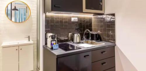 une cuisine avec un évier et un plan de travail dans l'établissement Le Shade of Grey - Studio Cosy & Compact - Marais, à Paris