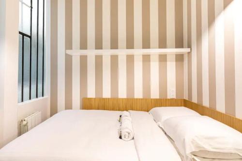 - 2 lits dans une chambre aux murs rayés dans l'établissement Le Shade of Grey - Studio Cosy & Compact - Marais, à Paris