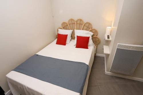 - une petite chambre avec un lit et 2 oreillers rouges dans l'établissement Superbe maison avec terrasse a quelques minutes des plages, à Latour-Bas-Elne