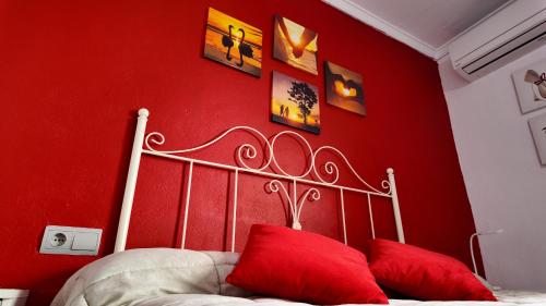 a bedroom with a red wall and a bed with red pillows at Apartalux Luna de las Negras in Las Negras