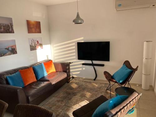 a living room with a couch and a flat screen tv at Gorgeous 1 Bedroom apartment close to Town Centre in Limassol