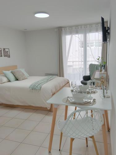 - une chambre avec un lit et une table avec des verres dans l'établissement Petite Luma, à Arles