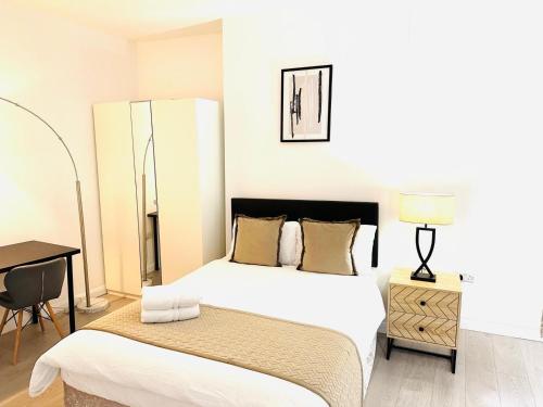 a white bedroom with two beds and a desk at Westferry in London