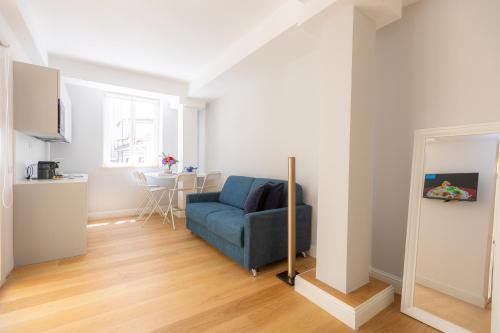 a living room with a blue chair and a table at Amazing Via del Corso 277 Suites in Rome