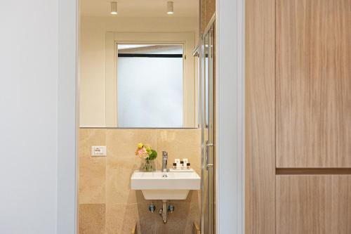a bathroom with a sink and a mirror at Amazing Via del Corso 277 Suites in Rome