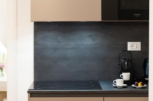 a kitchen with a black stove top with two cups at Amazing Via del Corso 277 Suites in Rome