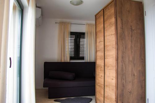 a large wooden closet with a black couch in a room at Kuća za odmor Komarica in Briševo