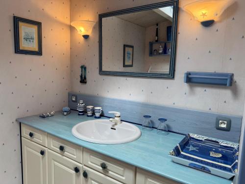 a bathroom with a sink and a mirror at ღ Ostaria - Maison Spacieuse, Piscine & Garage in La Couarde-sur-Mer