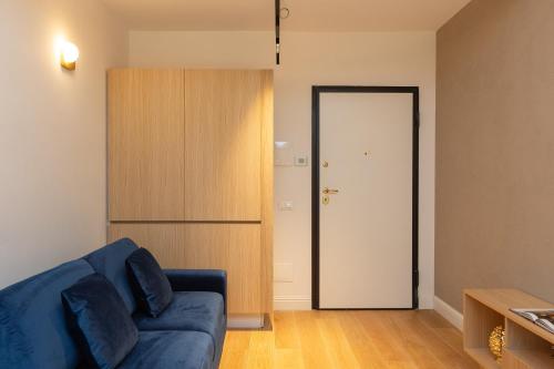 a living room with a blue couch and a door at Amazing Via del Corso 277 Suites in Rome