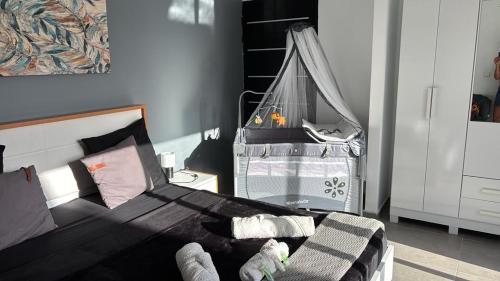 a bedroom with a black bed with a chair and a staircase at Villa Aux Oiseaux La contemporaine Somone Lagune in Somone