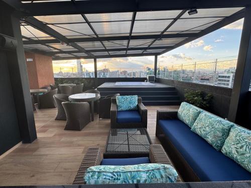 a rooftop patio with couches and chairs on a building at Comfort and style in Bogotá in Bogotá