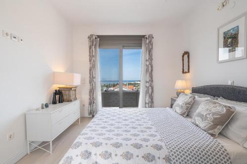 a white bedroom with a large bed and a window at Tranquil house in Kipséli