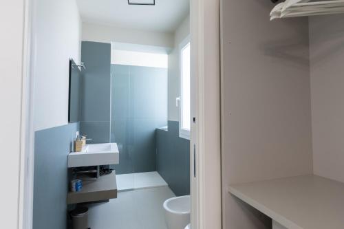 a bathroom with a white sink and a toilet at La Scala Suite in Realmonte