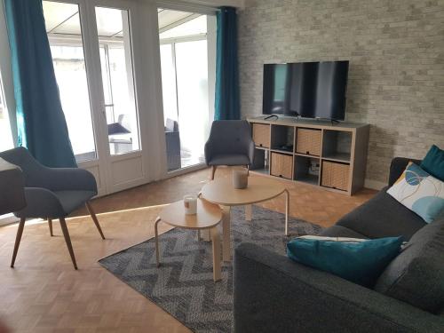 un salon avec un canapé et une télévision dans l'établissement Charmante maison de ville avec jardin, à Guingamp