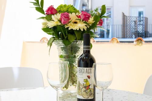 a vase with a bottle of wine and two glasses at Amazing Via del Corso 277 Suites in Rome