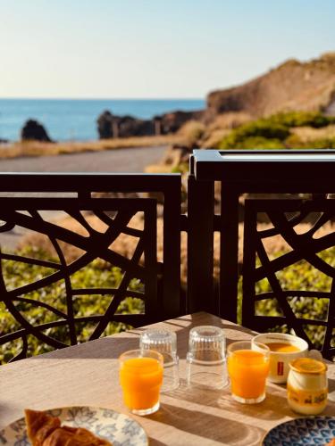 a table with glasses of orange juice and bread on it at Hôtel La Grande Conque in Cap d'Agde