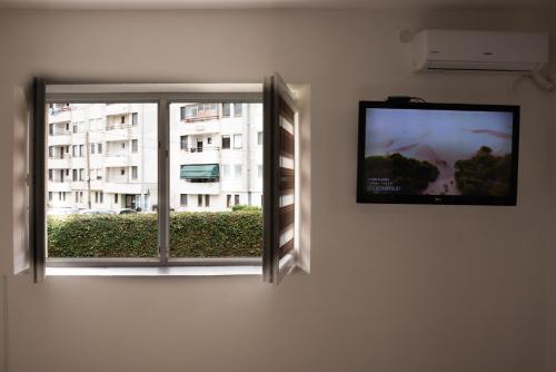 a flat screen tv on a wall next to a window at Iris Apartments in Ohrid