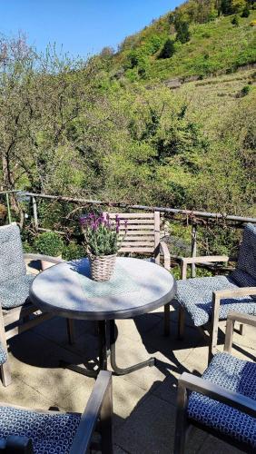 a table and chairs with a potted plant on a patio at Bergblick in Zell an der Mosel