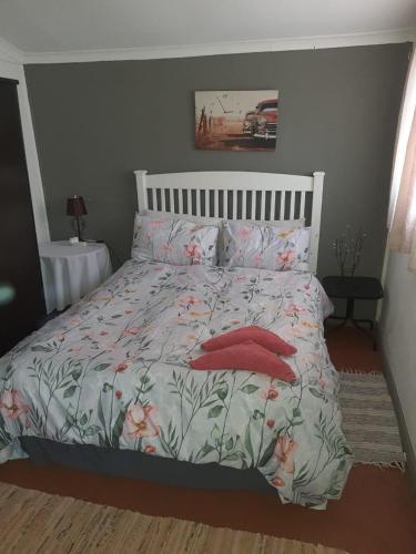 a bedroom with a bed with red pillows at Chalet 6 At Cynthias Country in Hartbeespoort