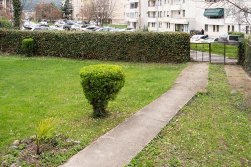 un buisson assis dans l'herbe à côté d'un trottoir dans l'établissement Iris Apartments, à Ohrid