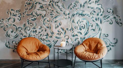two chairs and a table with a candle on a wall at Radisson Hotel & Apartments Gdansk in Gdańsk
