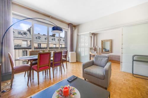un salon avec une table et des chaises et une chambre dans l'établissement Triangle d or Champs Elysées, à Paris