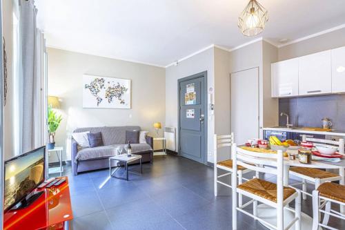 Il dispose d'une cuisine et d'un salon avec une table et un canapé. dans l'établissement PARADIS - Carré d’Or 1 room - Balcony Sea View, à Nice