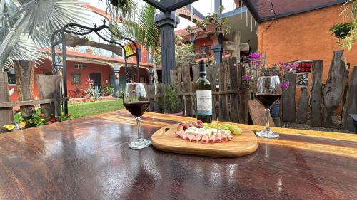 a table with two glasses of wine and a plate of food at Casa Punta Perula VILLAS in Pérula
