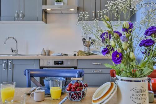 une cuisine avec une table avec un vase de fleurs dans l'établissement GARIB - Place Garibaldi - 4 rooms - Balcony, à Nice