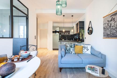 un salon avec un canapé bleu et une cuisine dans l'établissement GUIDONI - Superb City Center Suite Apartment, à Nice
