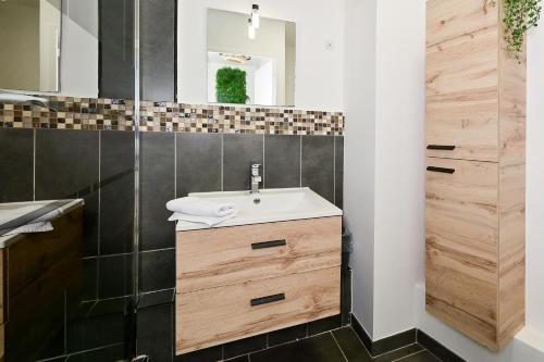 une salle de bain avec un lavabo et un miroir dans l'établissement Le Coeur de Nancy - 20min de la Gare, à Nancy