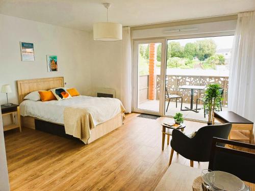 une chambre avec un lit et un balcon avec une table dans l'établissement La Résidence Cholet, à Cholet