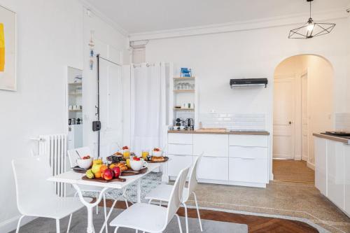 une cuisine blanche avec une table et des chaises blanches dans l'établissement MEDECIN 43 - Superb Bright City Center Apartment, à Nice