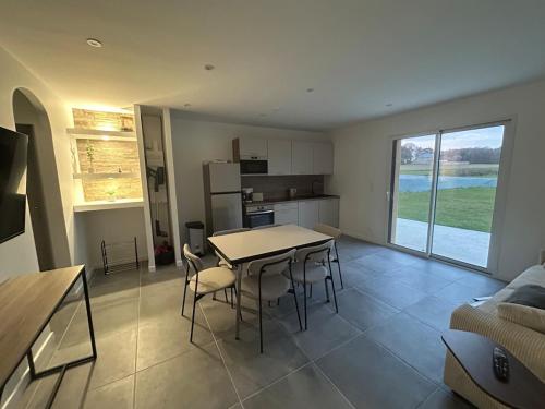 une cuisine et un salon avec une table et des chaises dans l'établissement La Lande Hilaire, à Saint-Ouen-des-Alleux