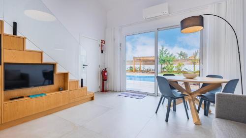 a living room with a dining table and a television at Blue Sky Villa by LovelyStay in Corroios