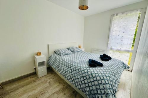 une chambre avec un lit avec deux chaussures dessus dans l'établissement Nice house with garden and terrace in La Rochelle, à La Rochelle