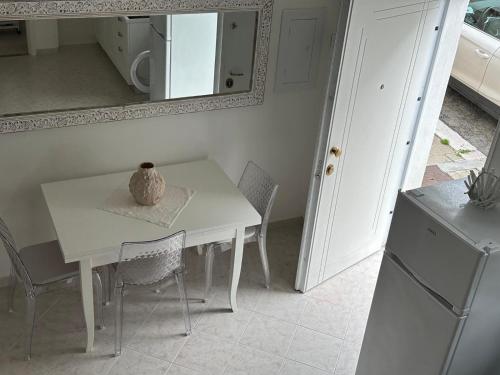 a white table and chairs in a kitchen with a mirror at Casa Vacanza LO SCRIGNO in Peschici