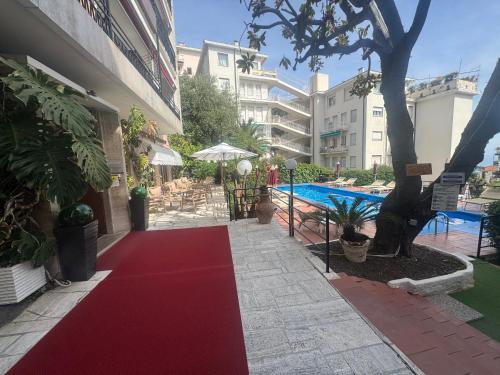 a red carpet in front of a building with a pool at Hotel Principe in Sanremo