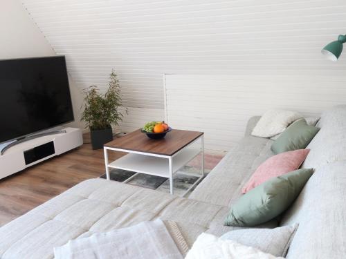 a living room with a couch and a table at Ferienhaus am Tannenbad in Bergen an der Dumme